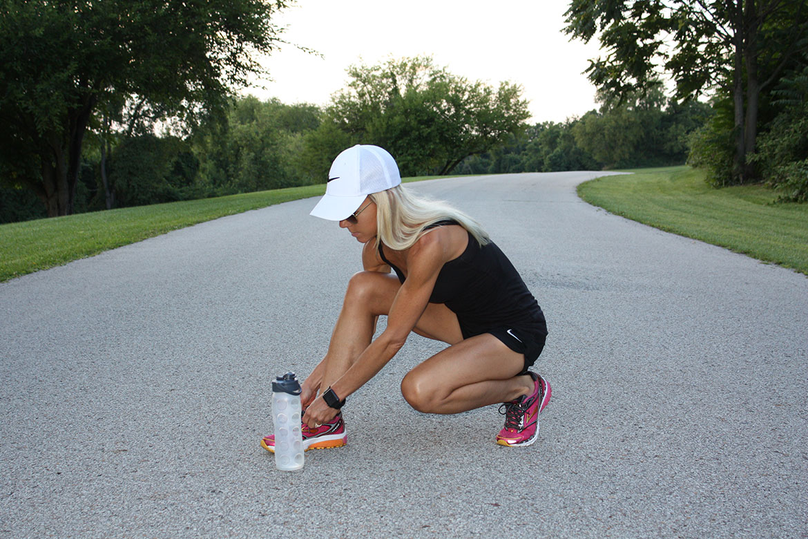 girl tying her athletic shoe outdoors