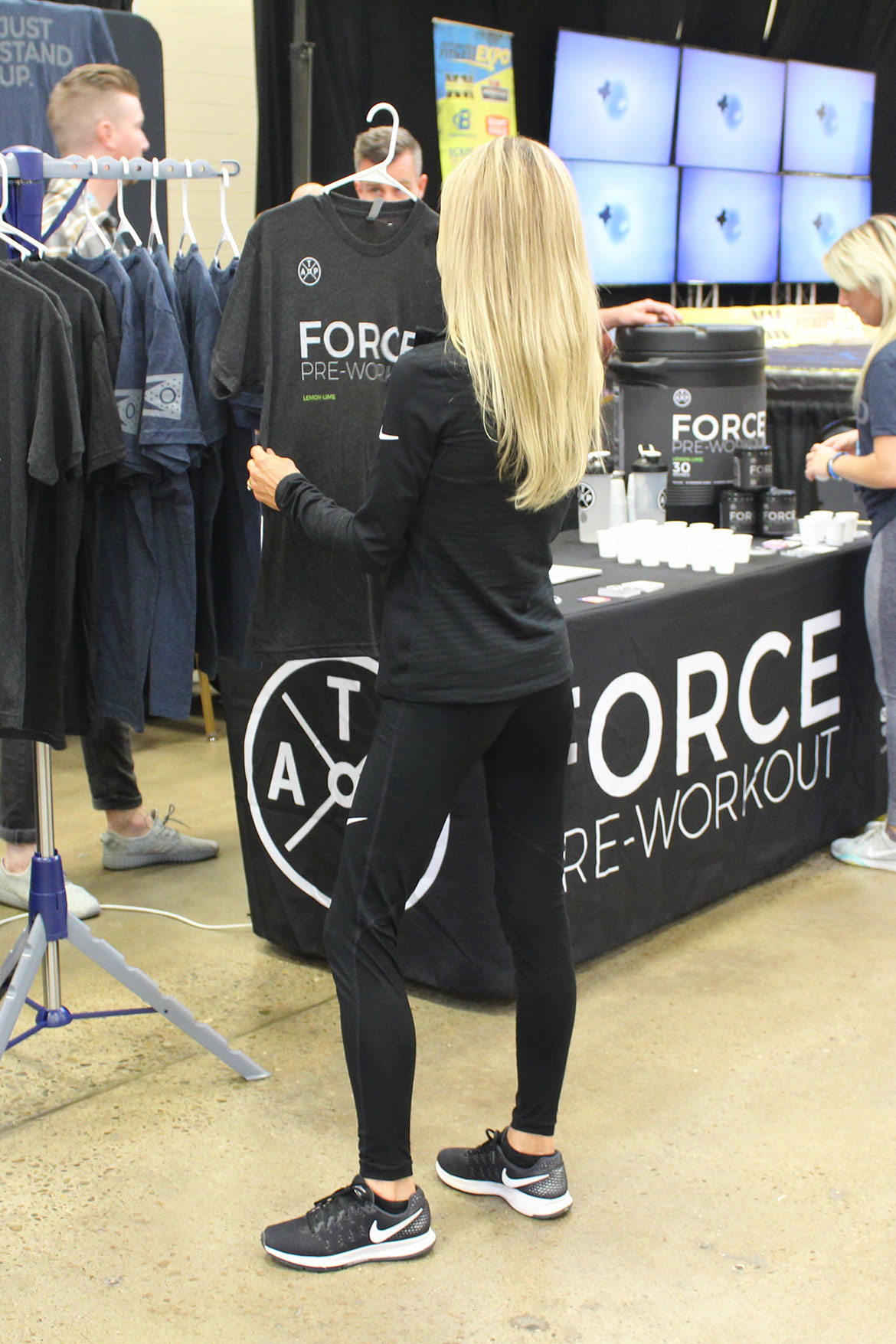 Deba Wilson Looking at a Graphic Workout Tee at a Health and Fitness Expo